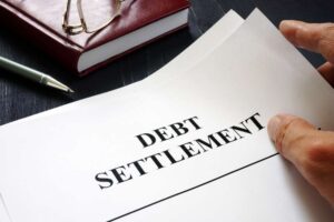 debt-settlement-documents-with-hand-and-pen-on-desk
